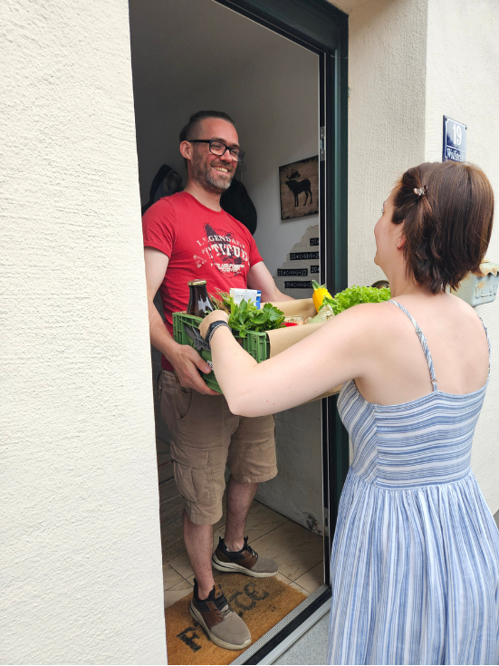 KI generiert: Zwei Personen halten einen Korb mit Gemüse und Obst.