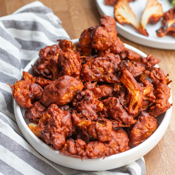 KI generiert: Das Bild zeigt eine kulinarische Szene mit frischem Lemon Curd in einem Glas, umgeben von Zitronen und Gebäck. Im Vordergrund sind zwei Gebäckstücke mit Lemon Curd bestrichen.